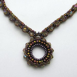 May include: A brown and iridescent beaded necklace with a circular pendant. The pendant is made of small beads and has a hole in the center.