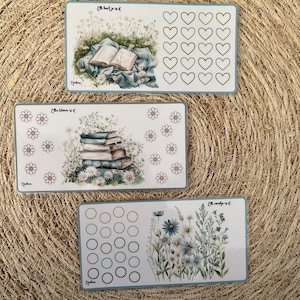 Puede incluir: Tres tarjetas rectangulares con ilustraciones florales y de libros. Una tarjeta presenta un libro abierto sobre una manta, otra muestra una pila de libros y la tercera tiene círculos y flores. Cada tarjeta tiene texto.