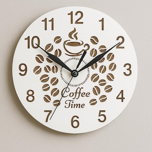 Peut inclure: Horloge murale ronde blanche avec des aiguilles noires et un motif de grains de café et de tasse marron. Le cadran de l'horloge comporte les mots "Coffee Time" et les chiffres de 1 à 12. Un objet décoratif pour une cuisine ou un café.