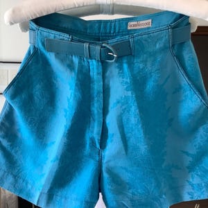 Peut inclure: Short bleu &agrave; motifs avec une ceinture noire et le texte "Gianni Versace" sur une &eacute;tiquette blanche.