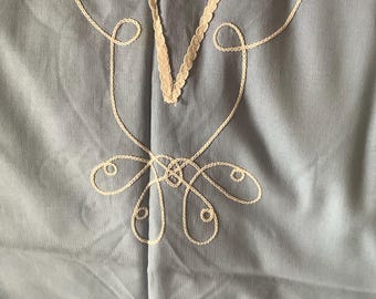 May include: A light blue fabric with white embroidered details. The embroidery features a series of loops and swirls.