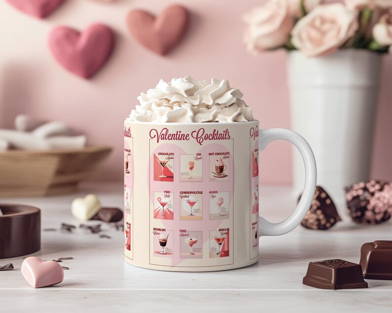 K&ouml;nnte beinhalten: Eine wei&szlig;e Keramiktasse mit einem rosa-wei&szlig;en Design, das eine Liste von "Valentine Cocktails" zeigt. Die Tasse ist mit Schlagsahne gef&uuml;llt und steht auf einer wei&szlig;en Oberfl&auml;che mit Schokoladenherzen und anderen Schokoladen.