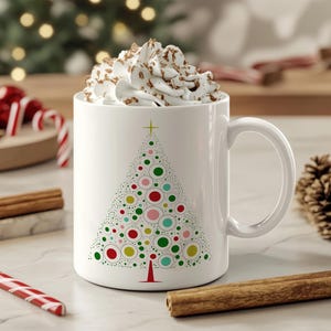 May include: White ceramic mug with a colorful Christmas tree design. The mug is filled with a white, foamy beverage.