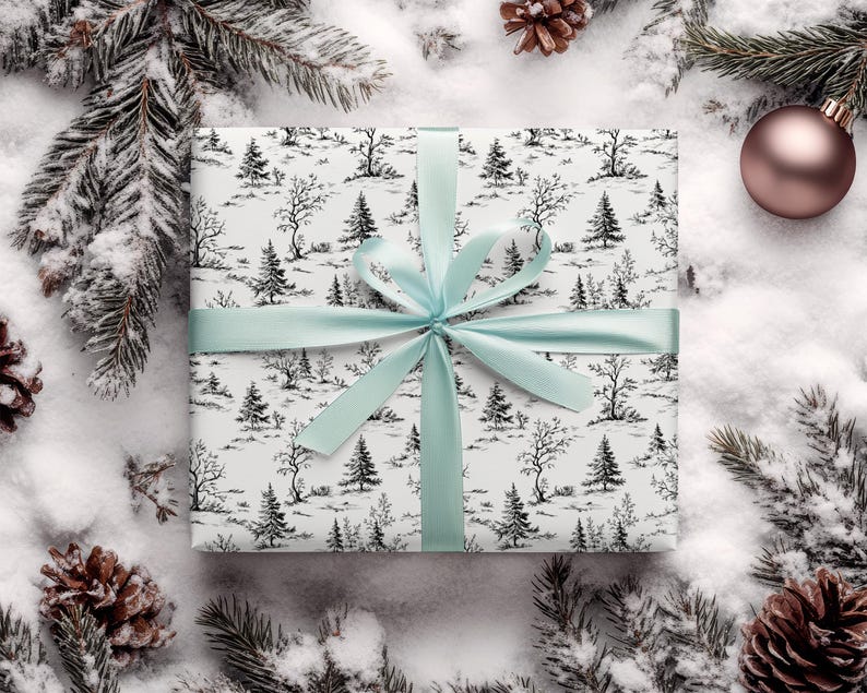 May include: A white gift box with a black and white winter forest print. The box is tied with a light blue ribbon.