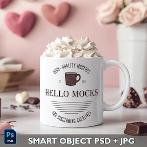 K&ouml;nnte beinhalten: Eine wei&szlig;e Keramiktasse mit einem schwarz-wei&szlig;en Design, auf dem "HIGH-QUALITY MOCKUPS EST 2024 HELLO MOCKS FOR DISCERNING CREATIVES" steht. Die Tasse ist mit Schlagsahne gef&uuml;llt und steht auf einer wei&szlig;en Oberfl&auml;che.