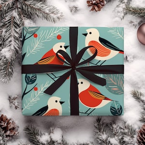 May include: A blue and green gift wrap with a black ribbon and a pattern of red and white birds on branches.