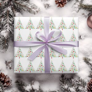 May include: White gift wrap with a repeating pattern of colorful Christmas trees. The trees are made up of small circles in shades of red, green, blue, yellow, and white. The gift wrap is tied with a lavender ribbon.