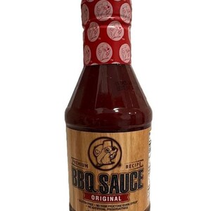 May include: A bottle of "Original BBQ Sauce" with a red cap featuring a repeating pattern. The label is brown with the text "BBQ Sauce" and a cartoon beaver. The bottle contains 20 oz (1.25 lbs) of sauce.