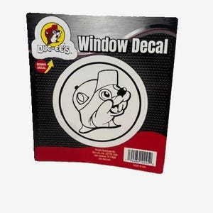 May include: A black and red window decal package featuring a circular graphic of a cartoon beaver wearing a hat. The package includes the text "Window Decal" and the Buc-ee's logo.