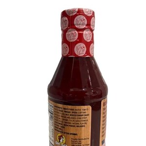 May include: A bottle of Buc-ee's brand sauce with a red cap featuring a repeating logo pattern. The bottle is filled with a dark red liquid and has a label with ingredient information. The label also includes the Buc-ee's logo.