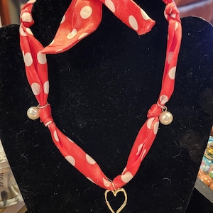 Handmade scarf necklace with charm and intricate details. Adjustable length.
