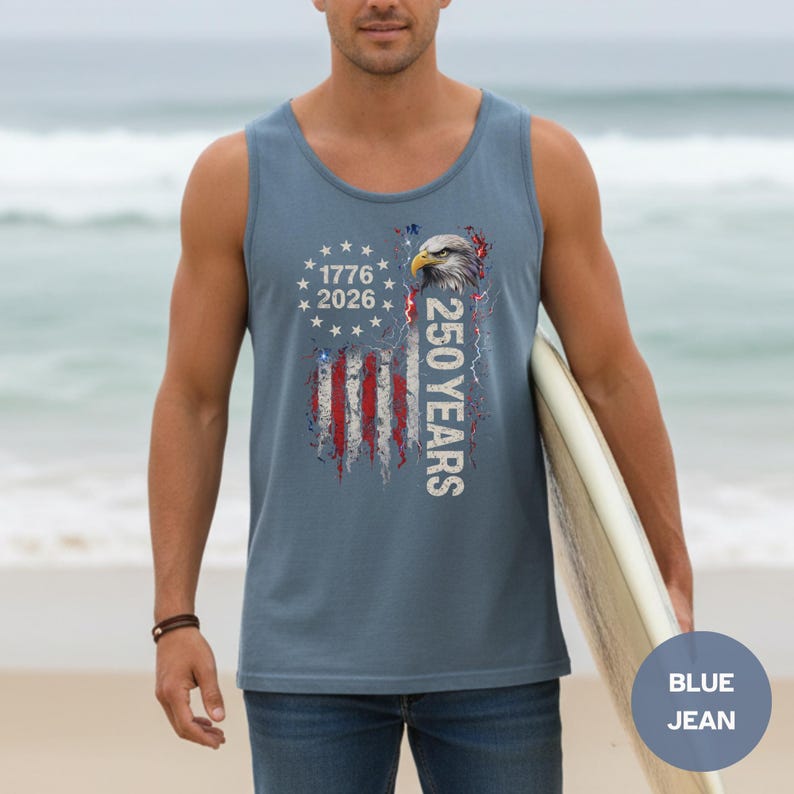The image showcases a Comfort Colors 9360 Midweight Tank Top featuring a patriotic design. The shirt prominently displays an eagle, the years "1776" and "2026," and a distressed American flag motif. This stylish T-shirt is available in nine colors and sizes ranging from S-3XL, making it a perfect choice for celebrating American pride during Independence Day, family gatherings, or casual outings. The heavyweight fabric ensures comfort and durability, making it an ideal addition to any wardrobe.