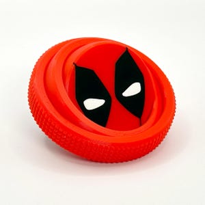 Puede incluir: Máscara de Deadpool impresa en 3D de color rojo y negro con un borde texturizado.