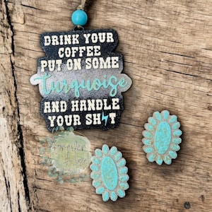 May include: A black and turquoise car charm with the text "DRINK YOUR COFFEE PUT ON SOME Turquoise AND HANDLE YOUR SH!T". Includes two turquoise and silver flower-shaped accessories. A turquoise bead hangs from the top.