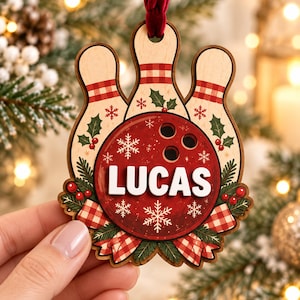 May include: A wooden Christmas ornament shaped like three bowling pins and a bowling ball. The ball is red with the name LUCAS in white letters, decorated with snowflakes, holly, and a red and white checkered ribbon, hanging from a red velvet ribbon.