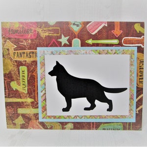 May include: A handmade greeting card featuring a black silhouette of a dog on a white background, framed by a light blue border. The card has a patterned background with arrows and words like "Fantastic" and "Playmate".