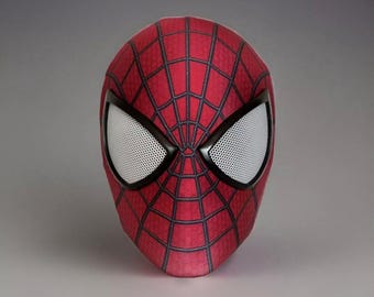 Puede incluir: Una máscara de Spider-Man roja y negra con un diseño de ojos de malla.