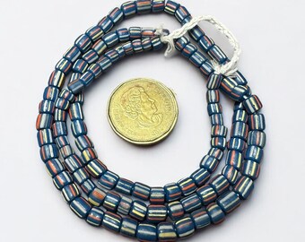 May include: Several strands of blue, red, yellow, and white striped beads. The beads are rectangular and strung together. A gold coin is next to the beads.