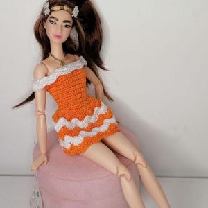 Orange knitted dress for Barbie dolls with different body types.