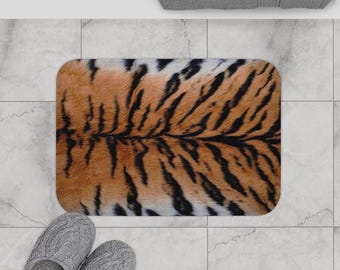 May include: A brown and black tiger print bath mat with a soft, fuzzy texture.