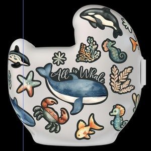 Op de afbeelding: Twee witte helmen met verschillende stickers met een oceaan thema. Op de ene helm staat de naam "Jacob". Op de andere helm staat de tekst "All is Whale".