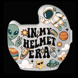 Könnte beinhalten: Hellgrauer Helm mit farbenfrohen Weltraum-Illustrationen. Eine Seite zeigt einen Astronauten, einen Außerirdischen und den Text "IN MY HELMET ERA". Die andere Seite trägt den Namen "DIEGO" und Weltraumgrafiken.