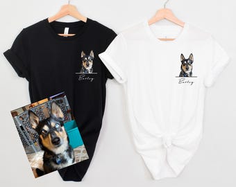 Puede incluir: Dos camisetas, una negra y una blanca, con una foto de un perro en la parte delantera. El perro es un husky negro y marrón con ojos azules. El texto "Barley" está impreso debajo de la foto.