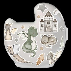 Puede incluir: Un biber&oacute;n gris claro con pegatinas de dragones en acuarela. Las pegatinas incluyen varios dragones, un castillo, estrellas y un arco&iacute;ris. Los dragones son en tonos verdes, marrones y grises.