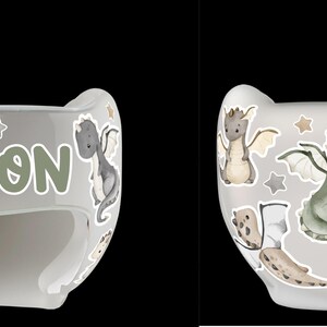 Puede incluir: Casco infantil gris claro decorado con dragones de dibujos animados, estrellas y un castillo. El nombre "AARON" est&aacute; impreso en verde en la parte delantera. El casco est&aacute; dise&ntilde;ado para proteger la cabeza de un beb&eacute;.