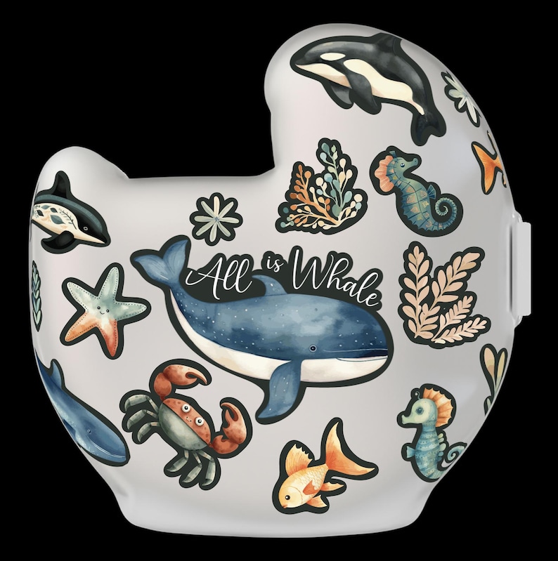 Op de afbeelding: Een witte keramische mok met een fantasierijk ontwerp met een oceaan thema. De mok heeft een blauwe walvis, een zeester, een krab, zeepaardjes en zeewier. De tekst "All is Whale" is geschreven in zwarte cursieve letters.