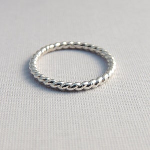 May include: A silver twisted band ring.