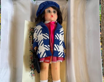 Muñeca Lenci hecha a mano en una colorida caja de presentación con certificado de autenticidad.