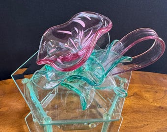 Caixa de joias hexagonal com tampa em vidro artístico com formato de flor, nas cores rosa e verde, design elegante.