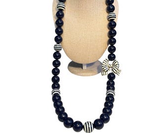 Naszyjnik z koralików w kolorze granatowym Kate Spade z wisiorkiem w kształcie kokardy w paski i złotymi akcentami