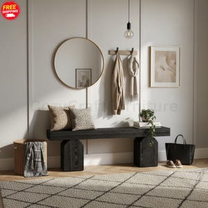 Peut inclure: Scène d'entrée moderne avec un banc en bois noir et un miroir rond doré. Un porte-manteau, des œuvres encadrées et des coussins sont visibles. Accessoires : panier, sac fourre-tout noir et tapis à motifs. Le banc mesure environ 150 cm de long.