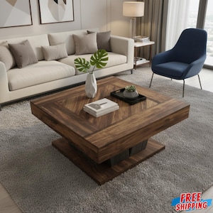 Può includere: Tavolino quadrato in legno scuro con motivo geometrico sulla parte superiore. Il tavolo ha un design a due livelli e poggia su un tappeto grigio. Un vaso bianco con foglie verdi, un vassoio nero e dei libri sono sul tavolo.