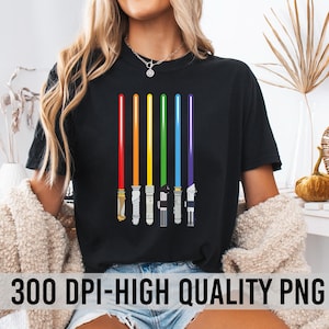 Könnte beinhalten: Schwarzes T-Shirt mit einem Design aus sechs farbigen Lichtschwertern in Rot, Orange, Gelb, Grün, Blau und Lila. Die Lichtschwerter sind vertikal angeordnet. Der Text "300 DPI-HIGH QUALITY PNG" befindet sich am unteren Rand des Shirts.