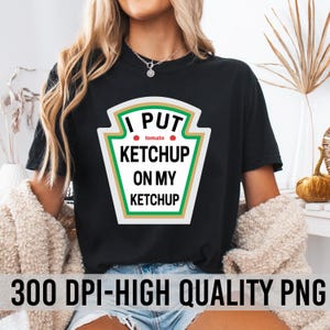 May include: A black t-shirt with a white ketchup bottle graphic that says "I put ketchup on my ketchup" with a red tomato graphic and the word "tomato" in white text.