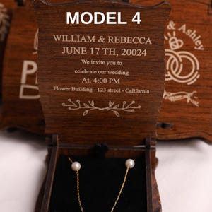 Puede incluir: Un joyero de madera con un collar de cadena dorada con tres perlas blancas. La caja está grabada con detalles de boda, incluyendo los nombres William & Rebecca, y la fecha 17 de junio de 20024.