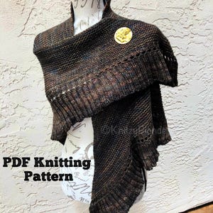 May include: A brown and black knitted shawl with a fringed edge. The shawl is draped over a mannequin and has a gold pin with a leaf design. The text "PDF Knitting Pattern" is visible at the bottom of the image.