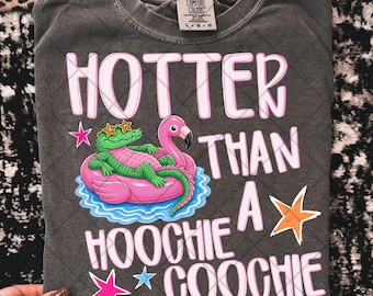 May include: Dark gray Comfort Colors t-shirt with the text "HOTTER THAN A HOOCHIE COOCHIE" in pink and white. The graphic features an alligator wearing sunglasses and a flamingo on a pink float. The shirt is a size L-G-G.