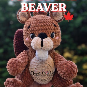 May include: A handmade brown crochet beaver plush toy with the text "MAPLE THE BEAVER" in red and white. The beaver has a white belly, black nose, and pink cheeks. A red maple leaf is also visible.