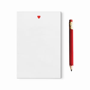 May include: A blank white notepad with a red heart in the top center and a red pencil with a gold eraser on the right side.