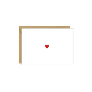 May include: A blank white card with a red heart in the center. The card is surrounded by a brown envelope.