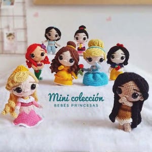 May include: A selection of crocheted princess dolls, each with distinct hairstyles and clothing. The dolls are in various colours, including yellow, blue, red, and pink. The text "Mini colección BEBÉS PRINCESAS" is visible.