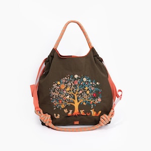 May include: A green canvas tote bag with a colorful embroidered tree and animals. The bag has orange rope handles.