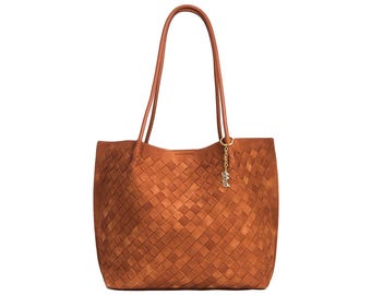 May include: A brown woven leather tote bag with long handles. The bag features a rectangular shape with a woven pattern and a small gold-colored charm hanging from the handle.