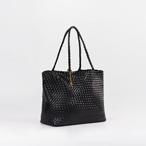 Pode incluir: Bolsa tote preta tecida com al&ccedil;as tran&ccedil;adas. A bolsa tem formato retangular e um pingente dourado pendurado em uma das al&ccedil;as. O padr&atilde;o de tecido &eacute; vis&iacute;vel em todo o exterior da bolsa.