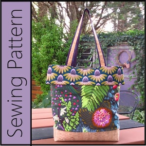 May include: A large tote bag with a cork bottom and a floral print fabric. The fabric has a dark green background with pink, white, and green flowers and leaves. The top of the bag is folded over and has a dark blue background with yellow and purple flowers.