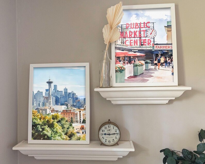 Callaghan Collective Watercolor Painting of Pike Place Market in Seattle Washington featuring the Public Market Center sign, red umbrellas, and the Farmers Market crowd, Pacific Northwest wall art for apartment or office decor.